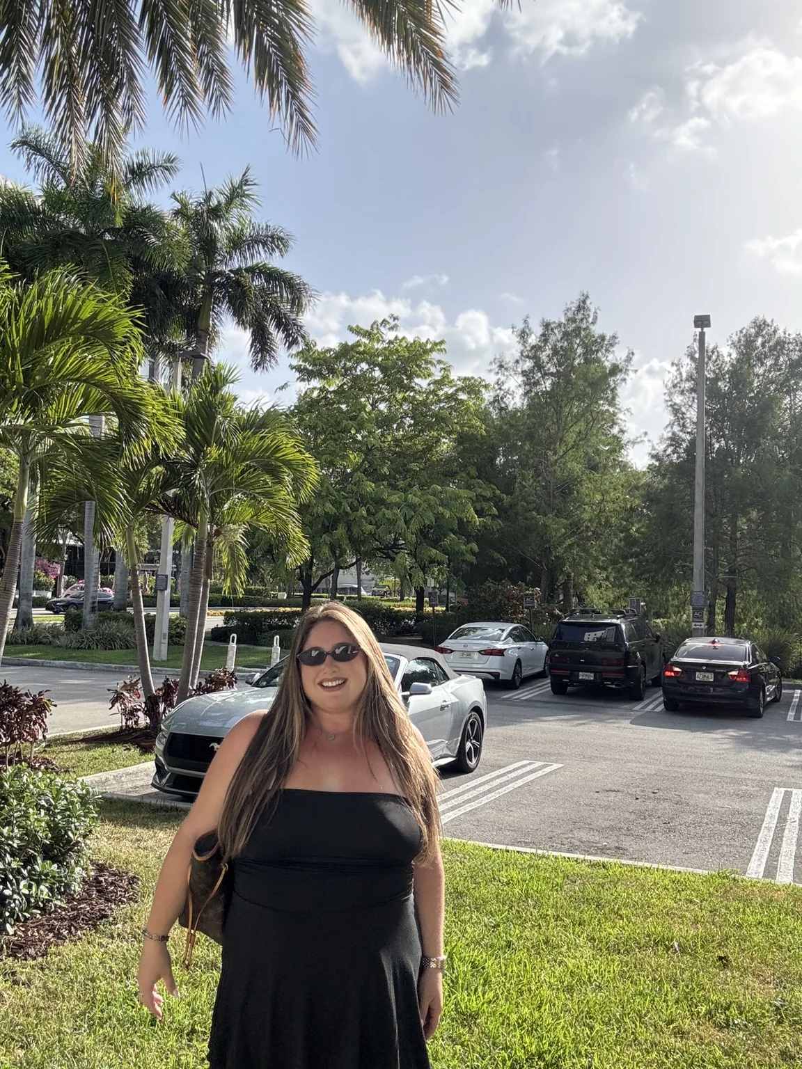 Taylor outdoors beneath palm trees