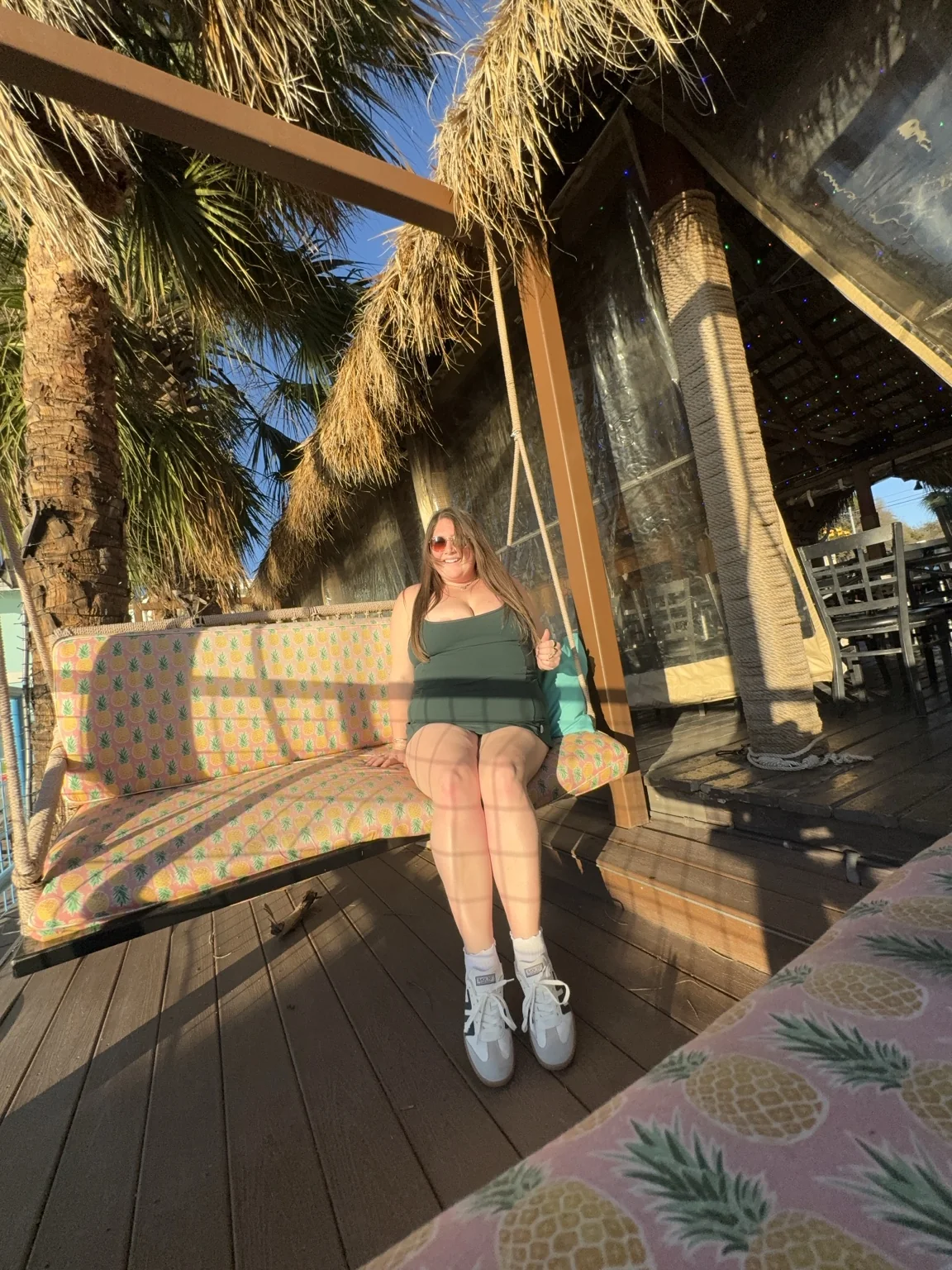 Taylor seated at a colorful tropical venue